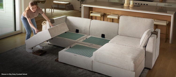 Woman rearranging her grey Lovesac sectional couch